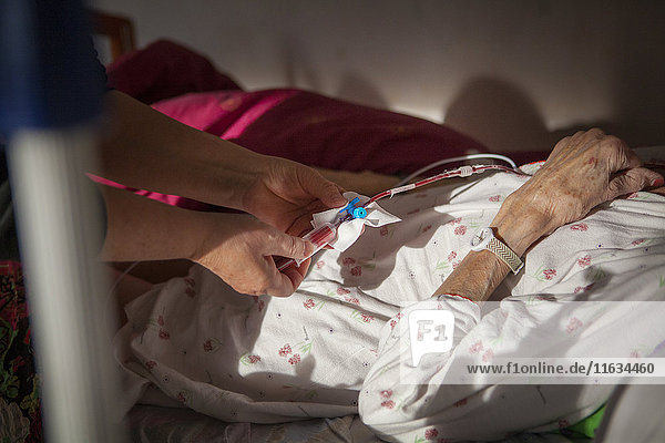 Reportage über einen häuslichen Pflegedienst in Savoie  Frankreich. Eine Krankenschwester führt bei einem krebskranken Patienten einen Bluttest durch.