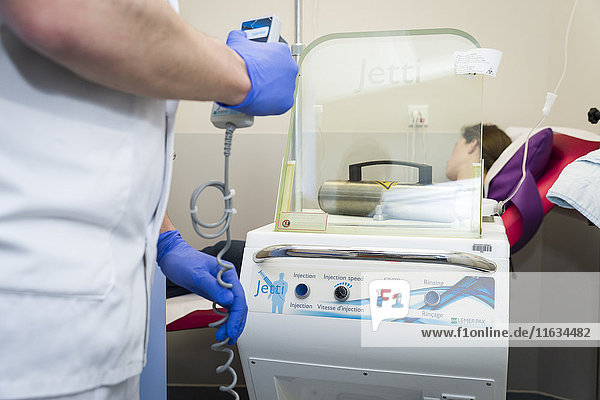 Reportage über PET-Bildgebung im Antoine-Lacassagne-Krebszentrum in Nizza  Frankreich. Die Positronen-Emissions-Tomographie (PET) wird zur Diagnose und Überwachung von Krebspatienten eingesetzt. Diese Methode ermöglicht den Nachweis von Tumoren mit Hilfe eines radioaktiven Tracers  der sich in Zellen  die einen pathologischen Hyperstoffwechsel aufweisen  stark anreichert. Injektion des radioaktiven Tracers. Der Tracer ist ein Glukosederivat  das mit einem Fluor-18-Molekül markiert ist.