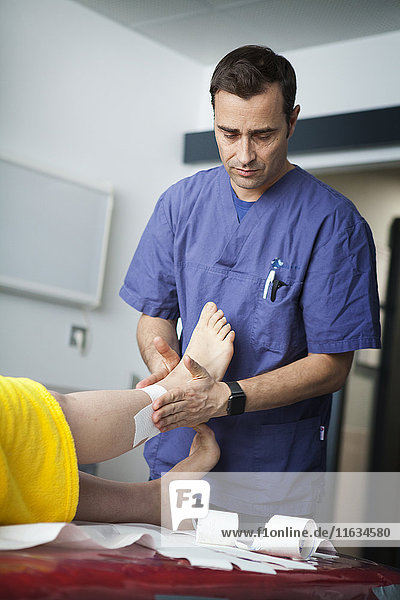 Reportage on a mountain rescue doctor working in both the Carroz and de Flaine ski resorts in Haute-Savoie  France. He treats skiers and snowboarders who have been injured on the slopes. A woman sees the doctor following a fall in the resort. The doctor bandages her ankle to support it.