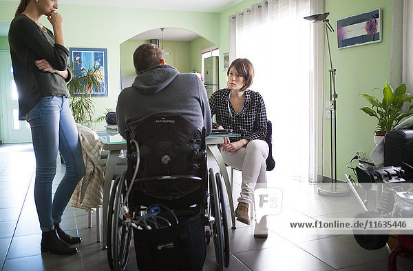 Reportage on a home health care service in Savoie  France. A nurse and auxiliary nurse chat to a patient.