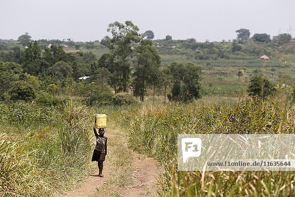 Ein ugandisches Kind holt Wasser.