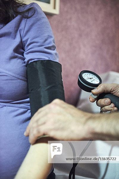 Reportage on a midwife in Lyon  France during a prenatal consultation. Taking a patient’s blood pressure is one of the vital tests to check a patient’s health.
