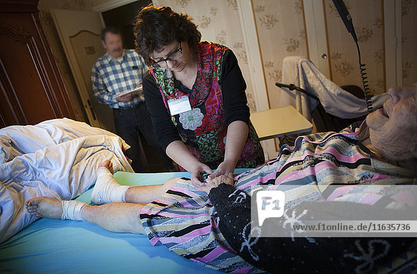 Reportage über einen häuslichen Pflegedienst in Savoie  Frankreich. Eine Krankenschwester überwacht die Sauerstoffzufuhr eines Patienten.