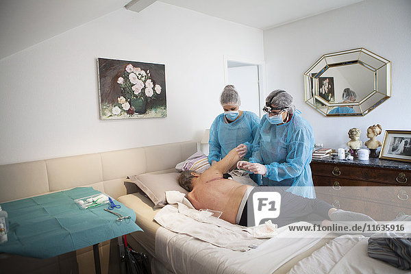 Reportage on a home health care service in Savoie  France. A nurse and auxiliary nurse place a VAC therapy dressing on a pulmonectomy.