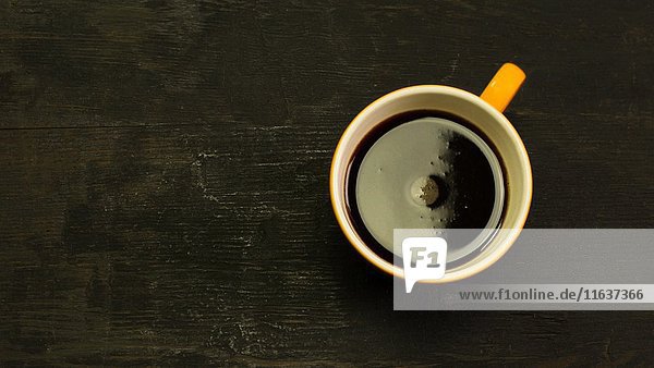 Kaffee wirbelt in der Tasse auf dem Holztisch  hohe Winkelansicht