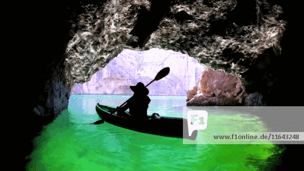 Silhouette eines Kajakfahrers in einer Höhle am Fluss