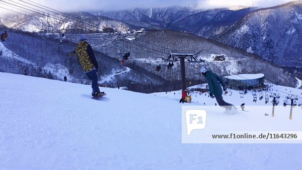 Skifahrer und Snowboarder auf der Piste