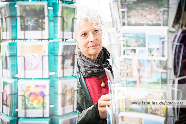 Frau betrachtet Postkarten  Bruniquel  Frankreich