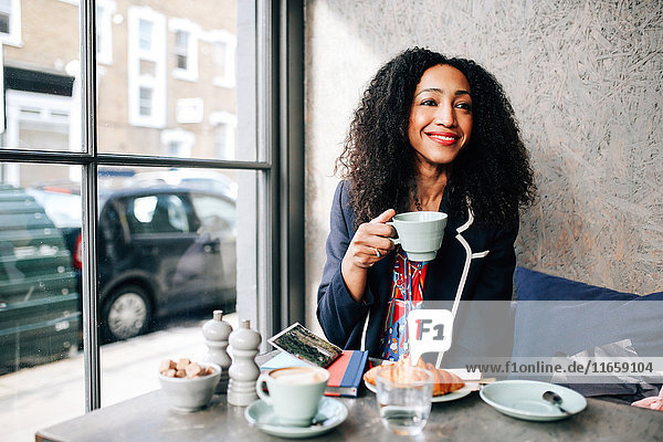 Mittlere erwachsene Frau mit Kaffeetasse im Cafe