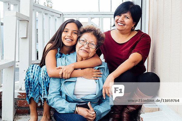 Porträt einer Mehrgenerationen-Familie  die lächelnd in die Kamera schaut