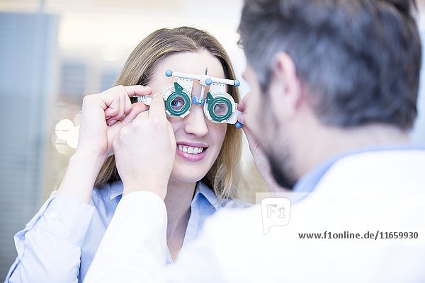Junge Frau bei einer Augenuntersuchung durch einen Optiker.