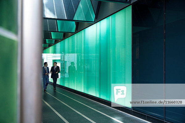 Geschäftsleute gehen durch modernes Glasgebäude  London  UK