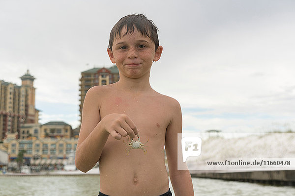 Junge mit blauer Krabbe  Golf von Mexiko  Smaragdküste  Florida  USA