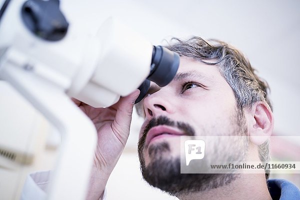Optometrist performing eye test in optometrist's shop  close-up.