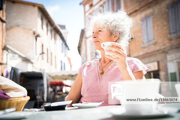 Frau im Straßencafé mit Blick in die Ferne  Bruniquel  Frankreich