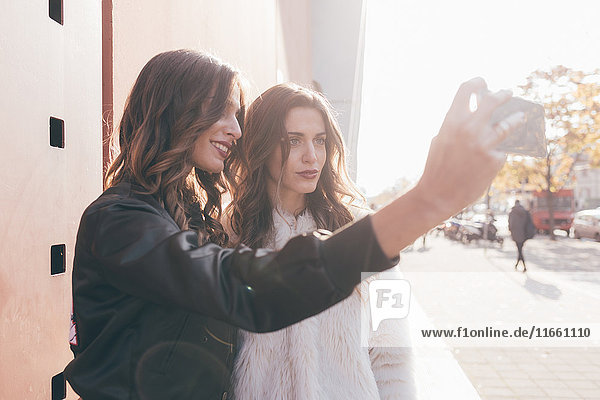 Zwillingsschwestern  draussen  Selfie  mit dem Smartphone