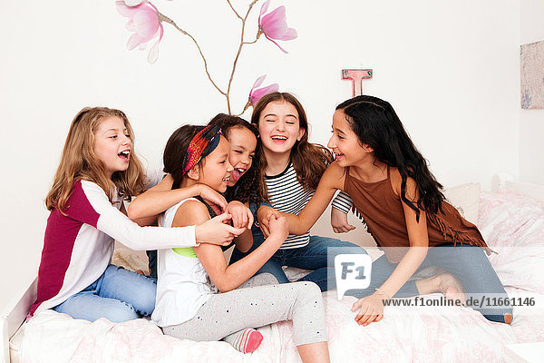 Mädchen im Bett  die lachend herumalbern