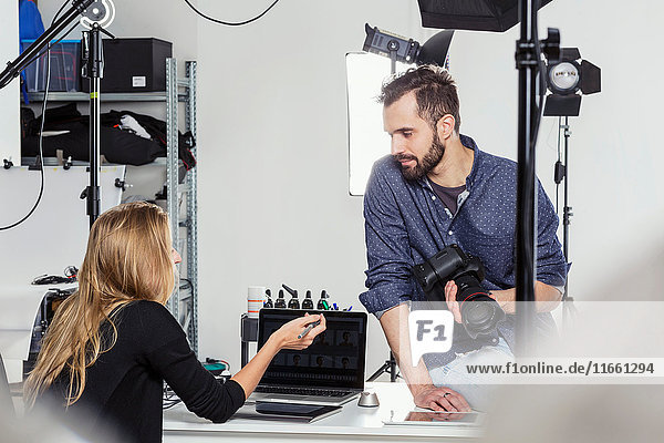 Stylist and photographer having discussion in photography studio