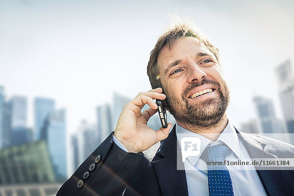 Businessman making smartphone call in city