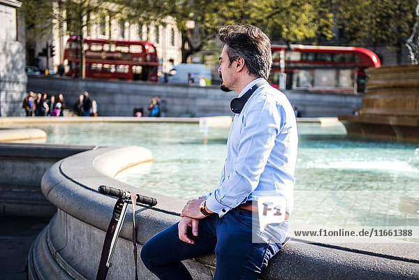 Businessman beside scooter  Trafalgar Square  London  UK