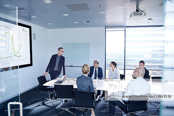 Geschäftsmann macht Flachbildschirm-Präsentation für Team im Sitzungssaal