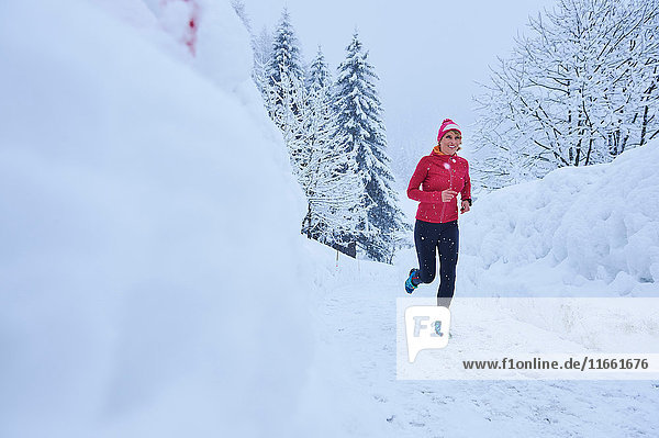 Female runner running on track in deep snow  Gstaad  Switzerland
