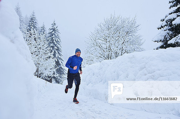 Männlicher Läufer läuft auf der Bahn im Tiefschnee  Gstaad  Schweiz