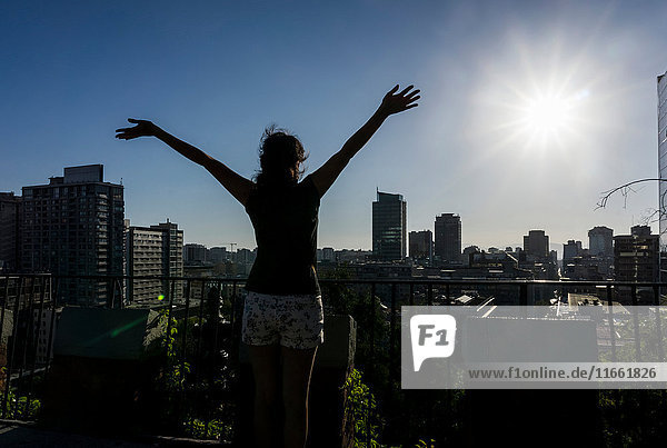 Woman with arms raised looking at view of Santiago de Chile Chile