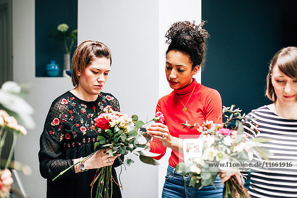 Floristikstudenten arrangieren Sträuße bei Blumenarrangement-Workshop