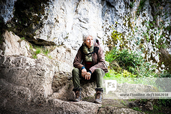 Auf Felsen sitzende und wegschauende Wanderfrau  Bruniquel  Frankreich