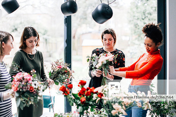 Florist und Studenten arrangieren Blumensträuße im Blumenarrangement-Workshop