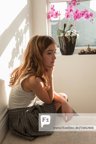 Girl sitting on top of stairs looking sad