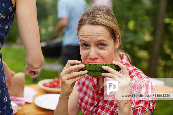 Frau isst Wassermelone im Freien