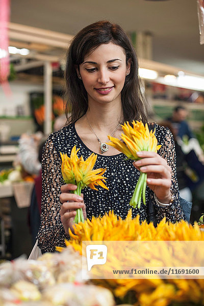 Frau wählt gelbe Blumen auf dem Markt