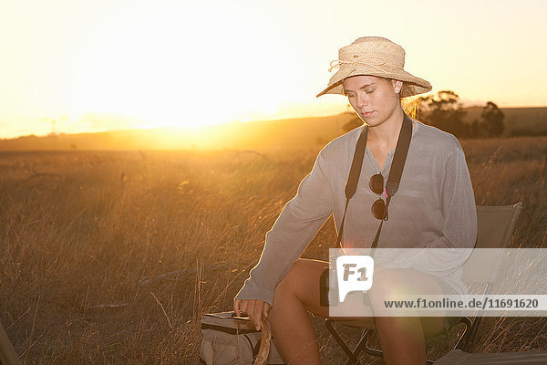 Junge Frau sitzt auf einem Stuhl auf Safari  Stellenbosch  Südafrika