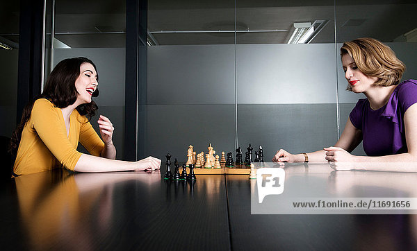 Zwei Geschäftsleute spielen Schach im Sitzungssaal