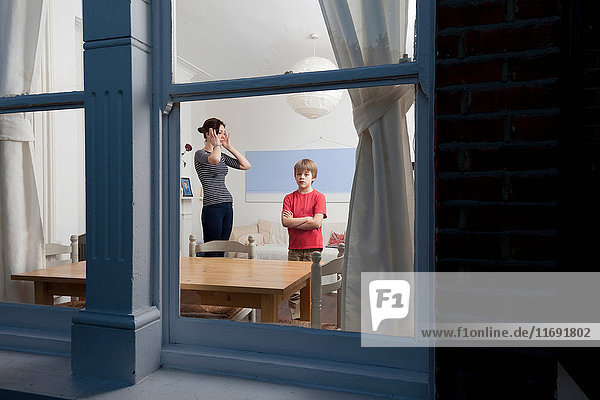 Mother and son viewed through window