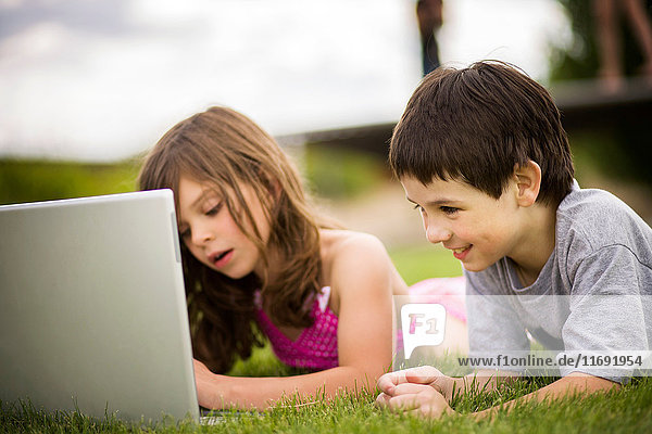 Kinder benutzen Laptop im Freien