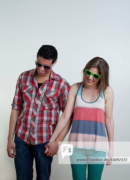 Junges Paar mit Sonnenbrille und lachend  Studioaufnahme