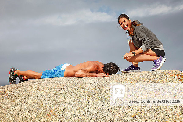 Couple laughing on boulder