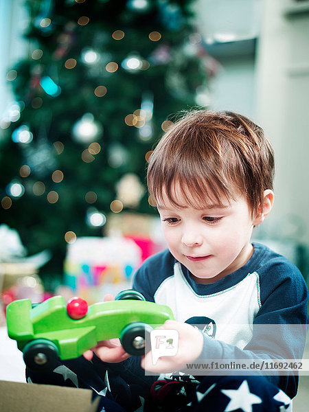 Junge öffnet Weihnachtsgeschenke
