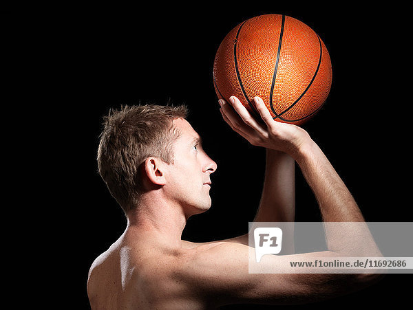 Halb bekleideter Basketballspieler vor schwarzem Hintergrund