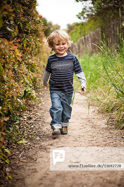 Boy walking on dirt track