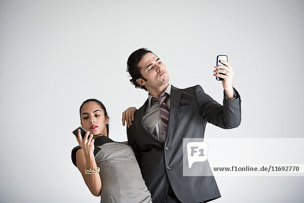 Business couple using cell phones