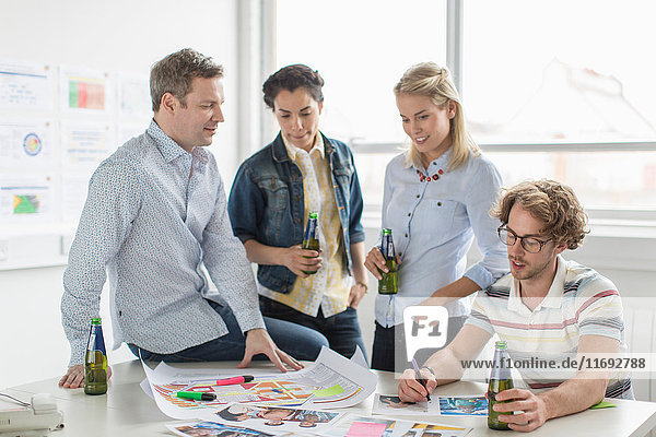 Office colleagues discussing creative plans on desk