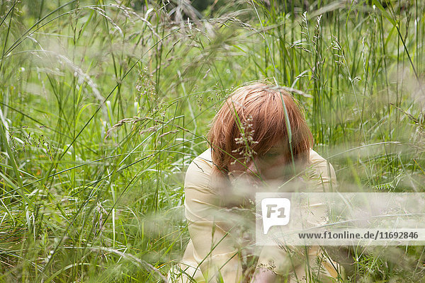 Young woman hiding in grass