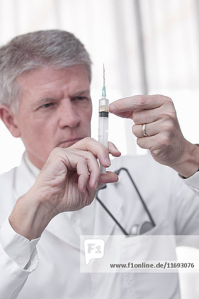 Doctor testing syringe in office