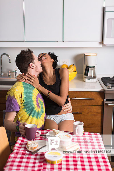 Junges Paar beim Frühstück  lachend