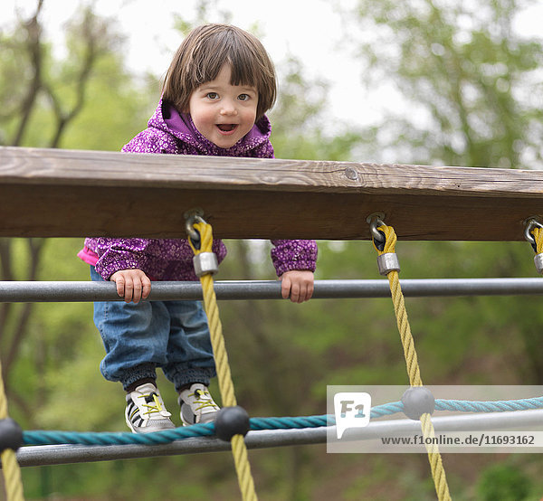 Junges Mädchen auf Klettergerüst auf dem Spielplatz  Porträt
