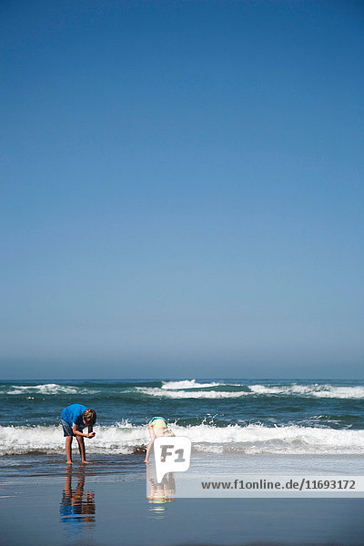 Junge und Mädchen sammeln am Strand von Manzanita  Oregon  USA